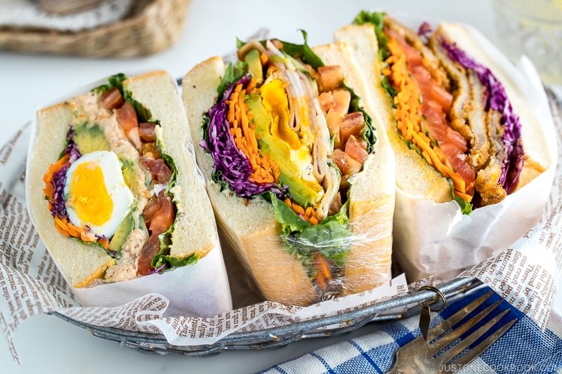 Colorful thick Japanese sandwich, Wanpaku Sandiwch (Sando), shows the filling and piles up on the table.