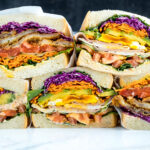 Colorful thick Japanese sandwich, Wanpaku Sandiwch (Sando), shows the filling and piles up on the table.