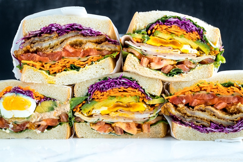 Colorful thick Japanese sandwich, Wanpaku Sandiwch (Sando), shows the filling and piles up on the table.