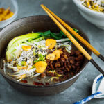 A black bowl containing Black Sesame Dan Dan Noodles.