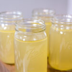 Mason jars containing Homemade Chicken Stock.