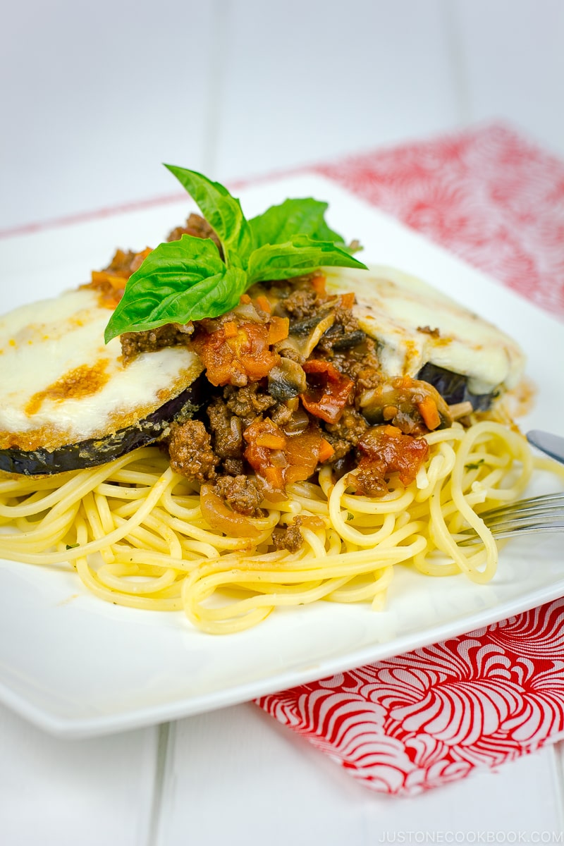 A white plate containing Eggplant Parmesan Spaghetti.