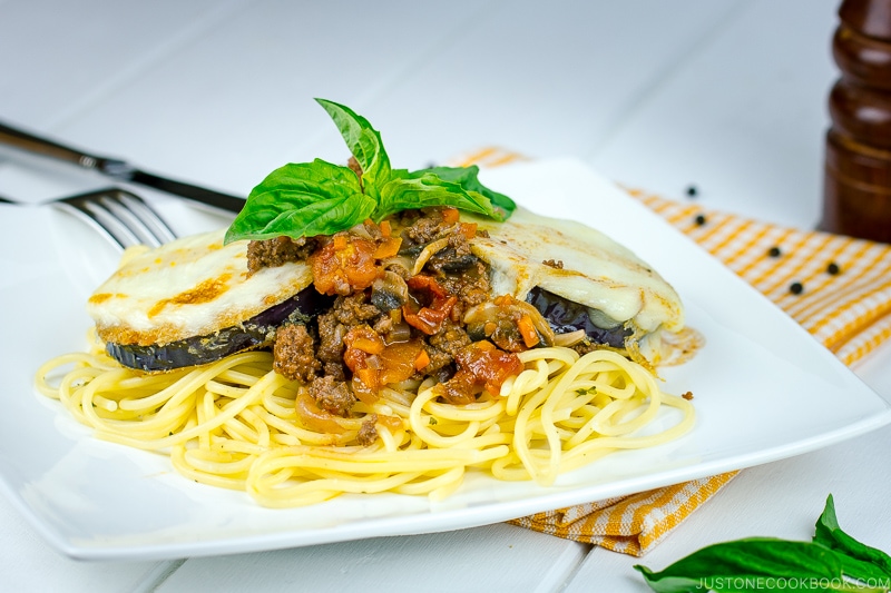 A white plate containing Eggplant Parmesan Spaghetti.