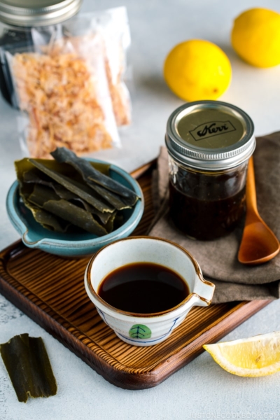 A Japanese ceramic containing Homemade Ponzu Sauce. It's on a tray along with all the ingredients used for the sauce.