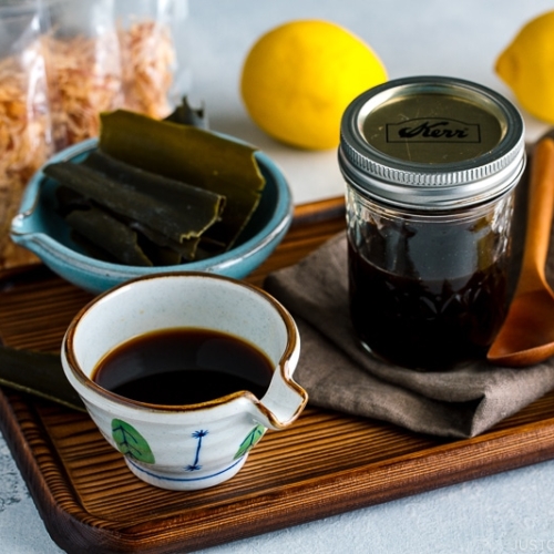 A Japanese ceramic containing Homemade Ponzu Sauce. It's on a tray along with all the ingredients used for the sauce.