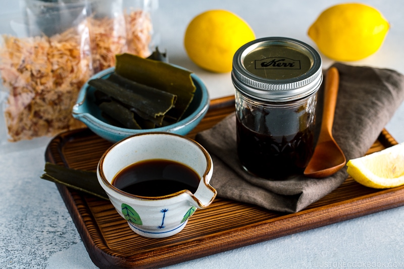 A Japanese ceramic containing Homemade Ponzu Sauce. It's on a tray along with all the ingredients used for the sauce.