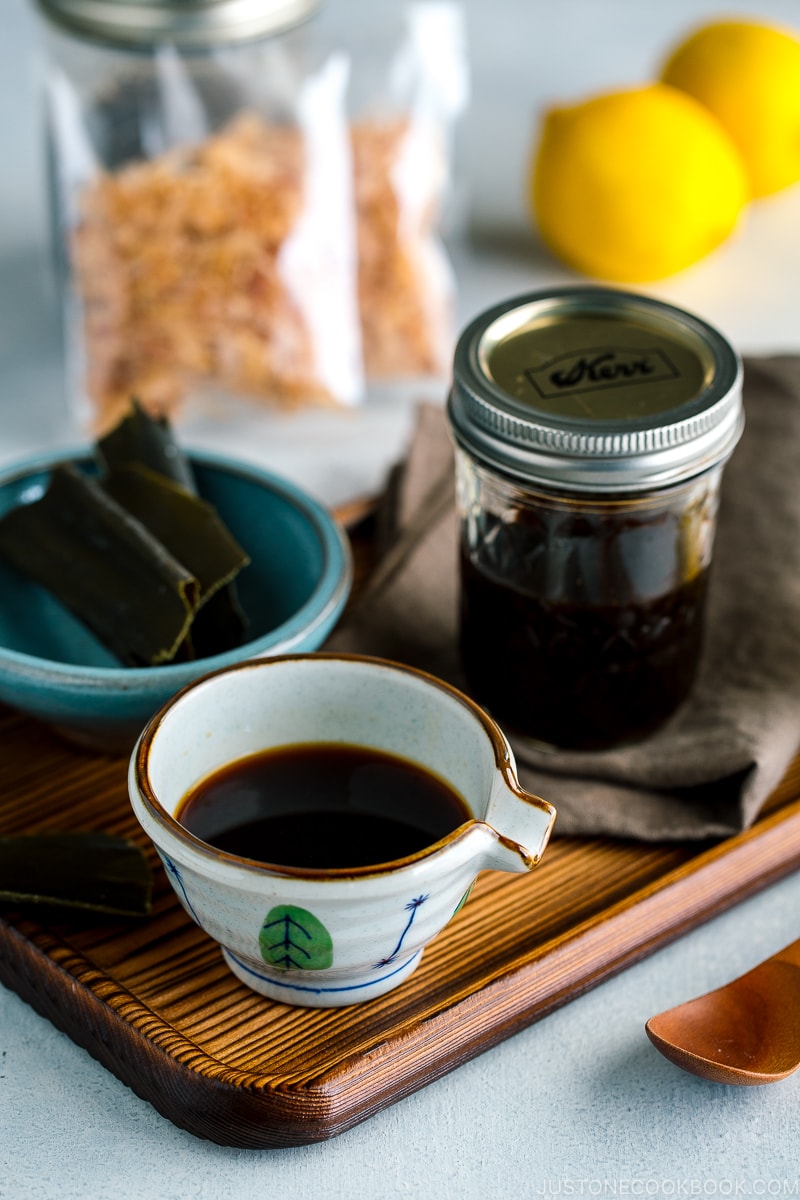 A Japanese ceramic containing Homemade Ponzu Sauce. It's on a tray along with all the ingredients used for the sauce.