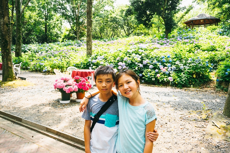 girl and boy in front of hydrangea flowers