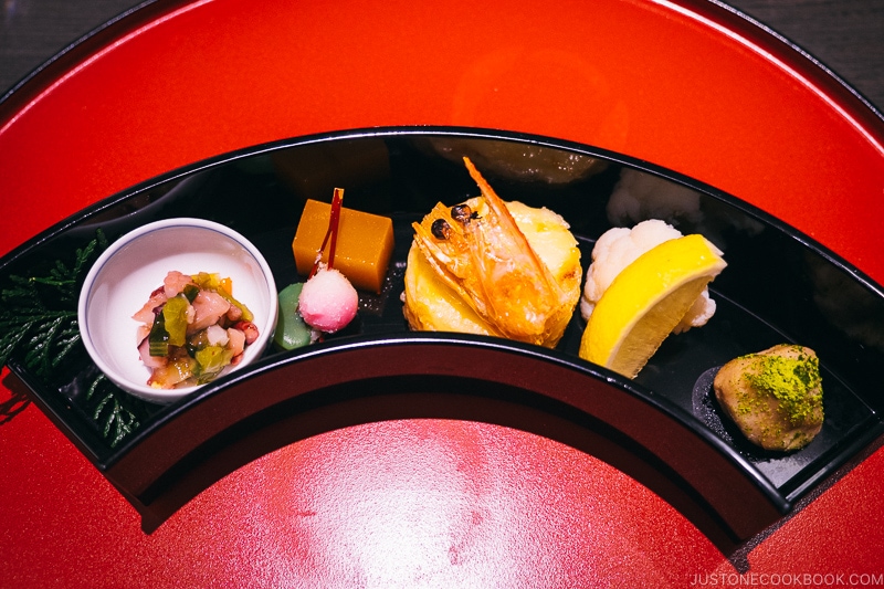 assorted appetizer in a black moon shape bowl