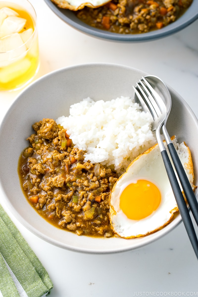 A bowl containing Keema Curry, steamed rice, and a fried egg.