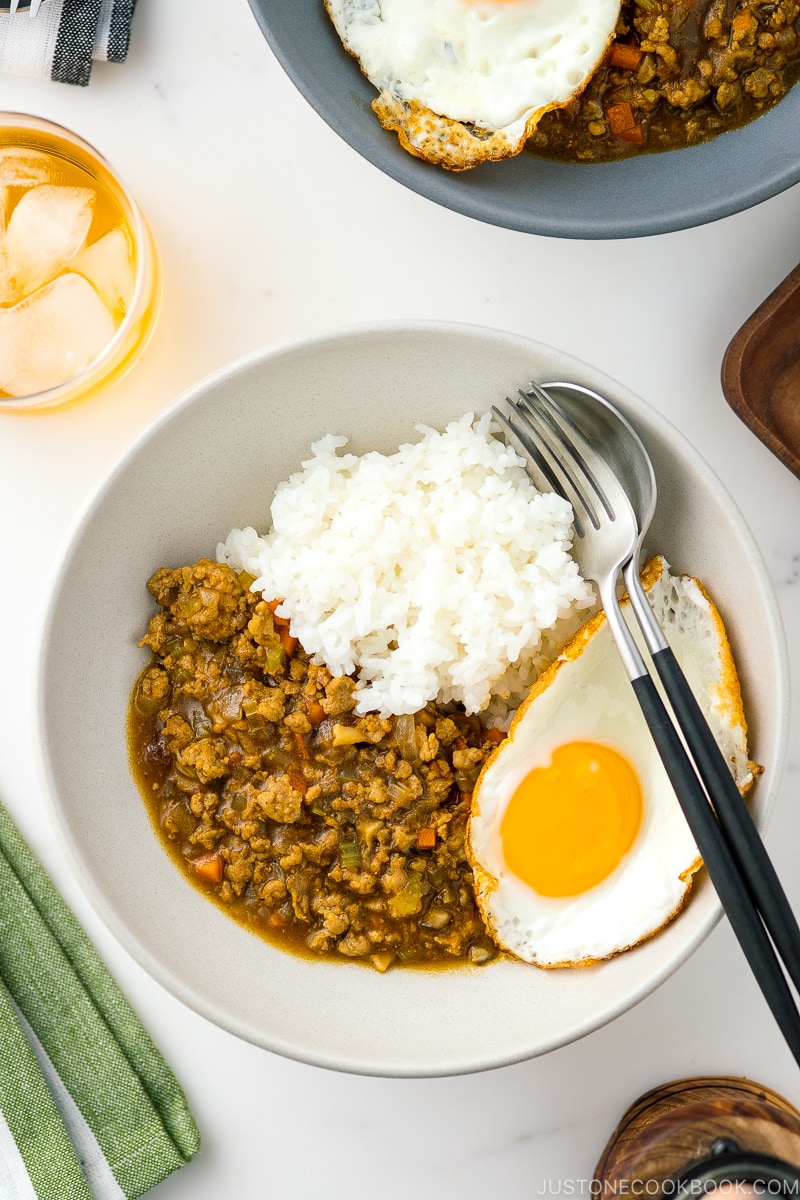 A bowl containing Keema Curry, steamed rice, and a fried egg.