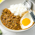 A bowl containing Keema Curry, steamed rice, and a fried egg.