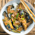 A bowl containing Miso Pork and Eggplant Stir-Fry over steamed rice.