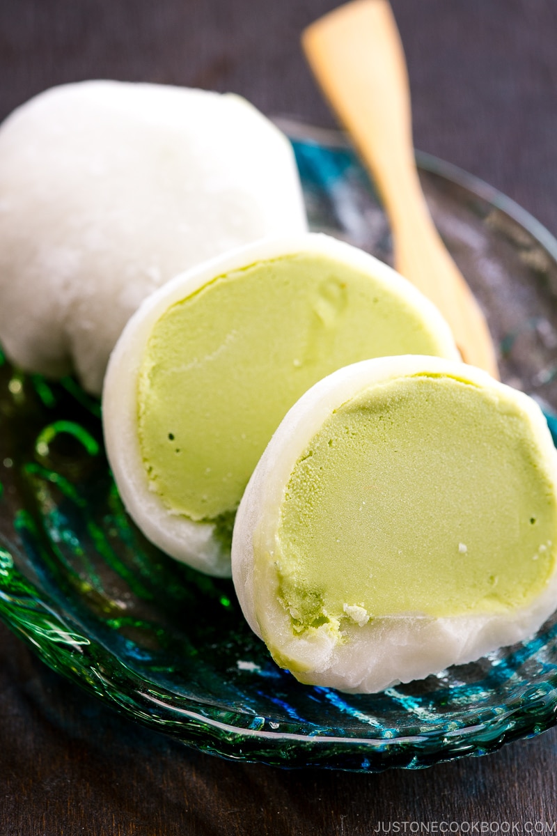 Green tea mochi ice cream on a glass plate.