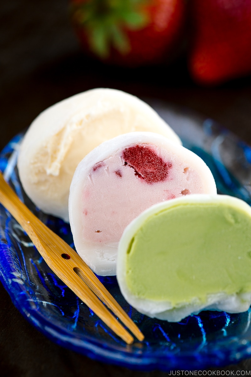 Vanilla, strawberry, and matcha mochi ice cream served on a glass plate.