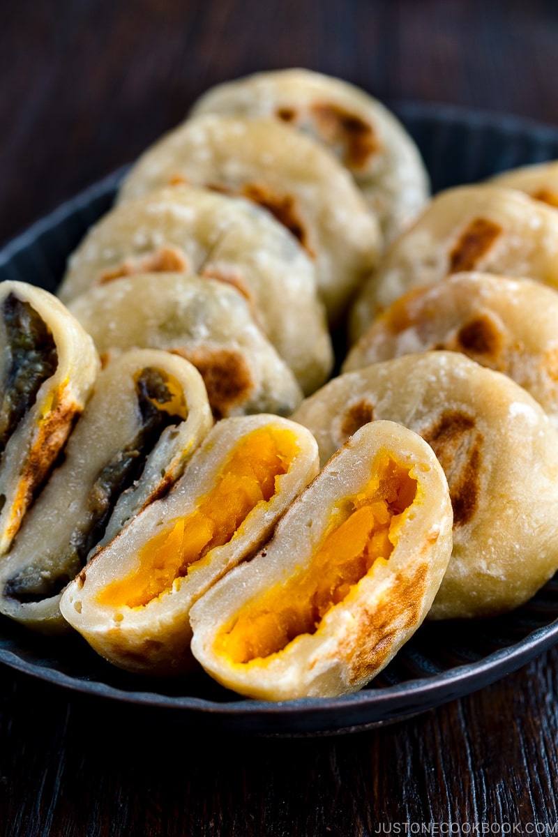 A dark plate containing Kabocha and Eggplant Oyaki (Japanese Stuffed Dumplings).