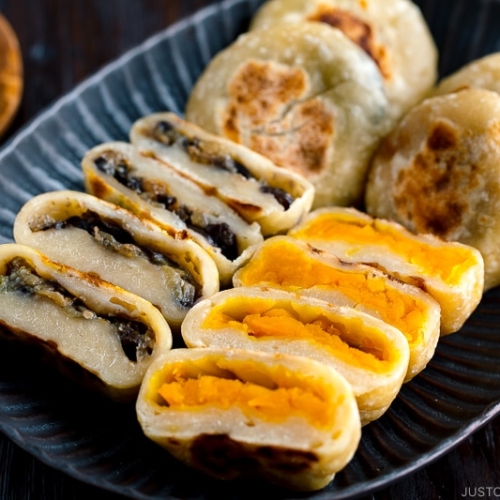 A dark plate containing Kabocha and Eggplant Oyaki (Japanese Stuffed Dumplings).