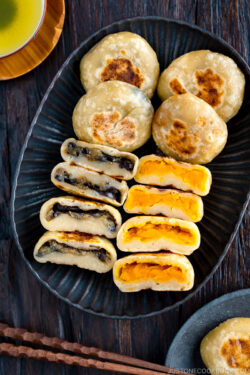 A dark plate containing Kabocha and Eggplant Oyaki (Japanese Stuffed Dumplings).
