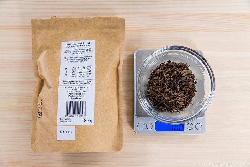 10 grams of hojicha on a scale next to a package on cutting board