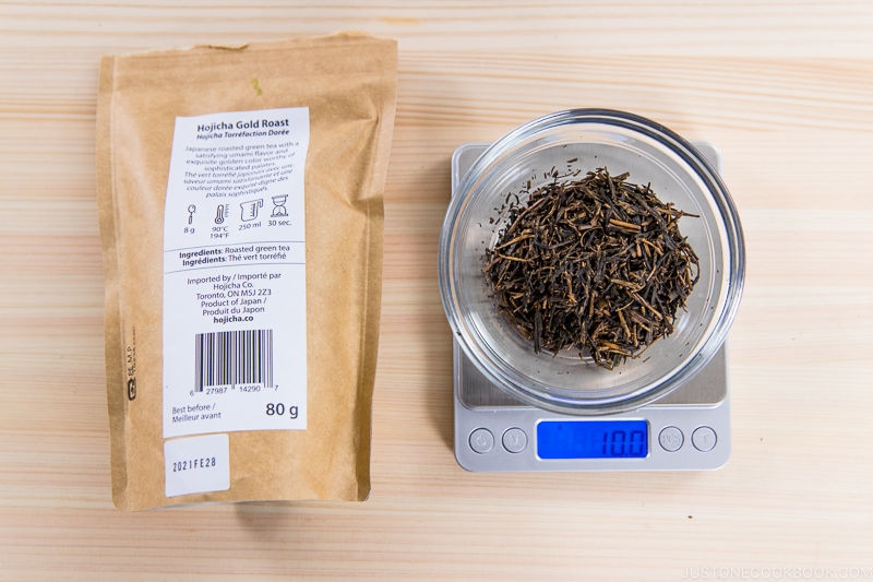 10 grams of hojicha on a scale next to a package on cutting board