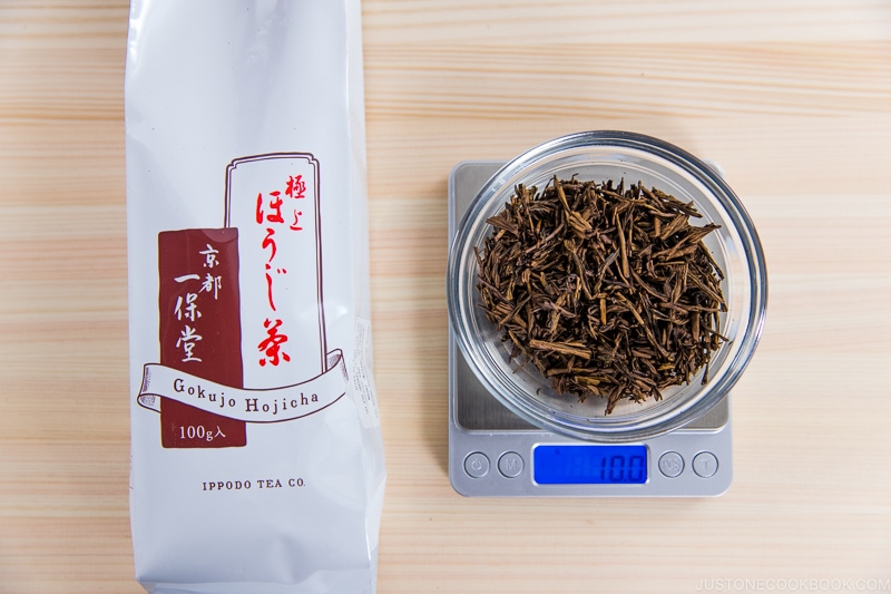 10 grams of hojicha on a scale next to a package on cutting board