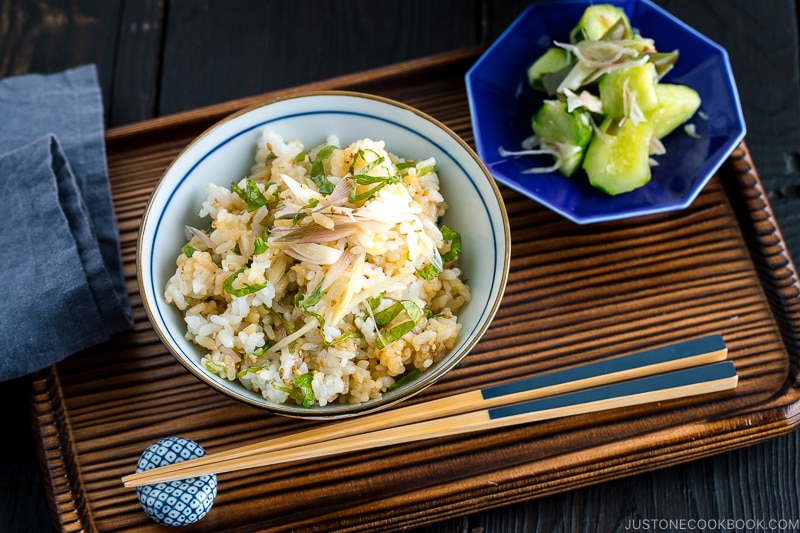 A Japanese rice bowl containing Myoga Shiso Rice (Mazegohan) served with pickled cucumber.