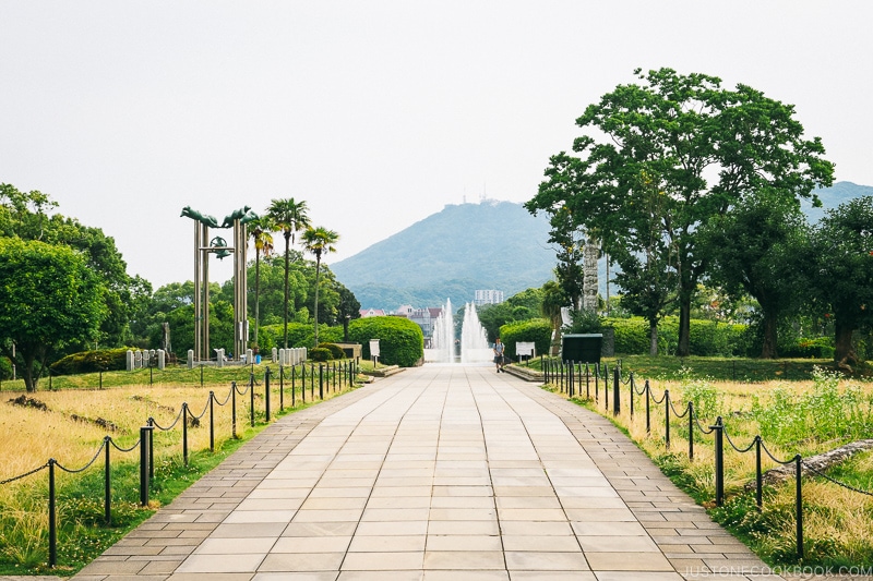 a walkway with fountain at the end