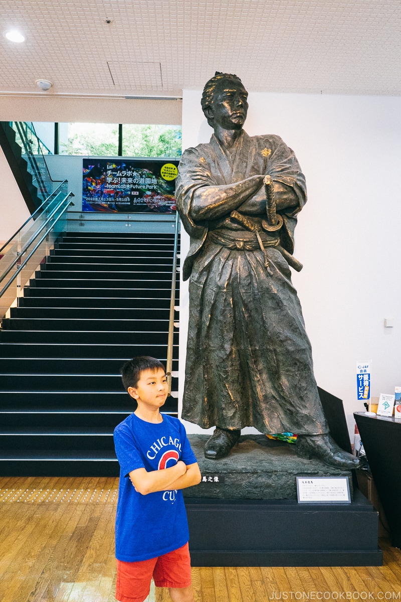 boy in front of a Sakamoto Ryōma statue