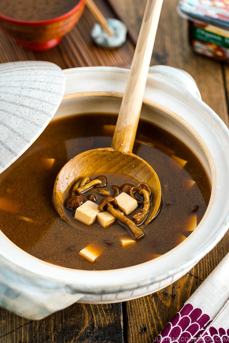 A white Japanese donabe (earthenware pot) containing Nameko Mushroom Miso Soup.