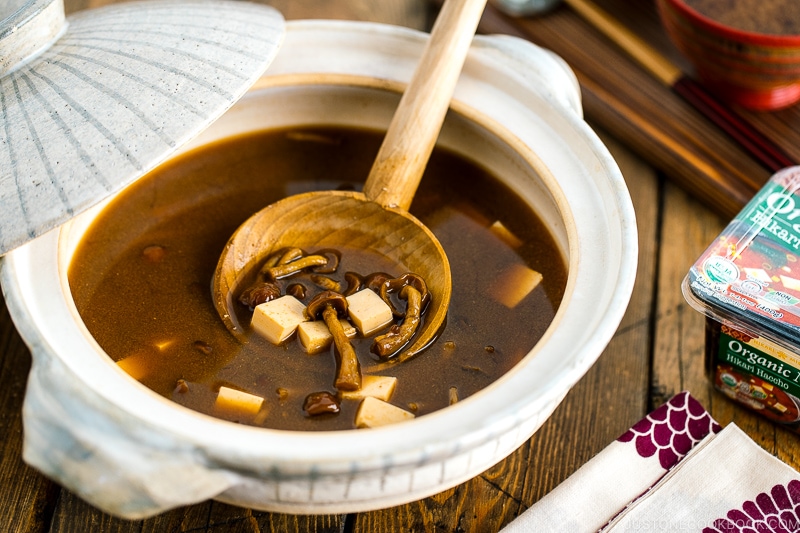 A white Japanese donabe (earthenware pot) containing Nameko Mushroom Miso Soup.