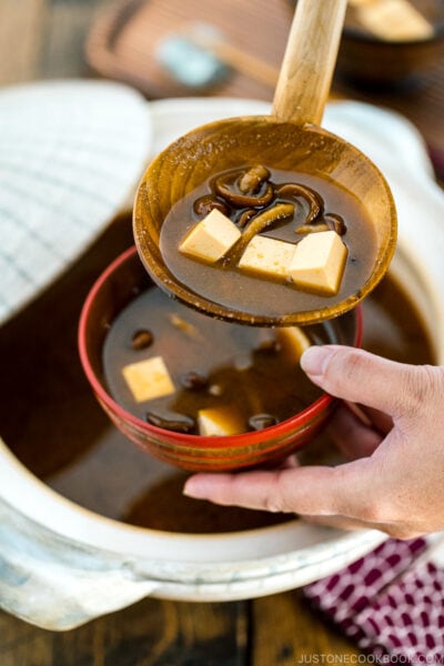 Nameko Miso Soup being served fro a donabe to a wooden bowl.