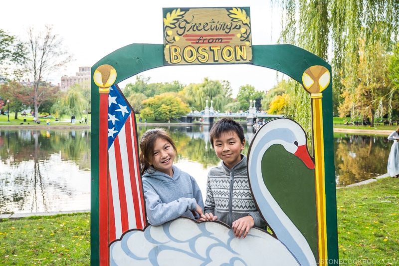 two children standing in a Greetings from Boston frame