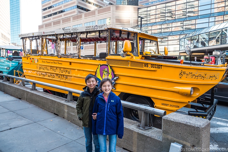 two children standing in front of a Ducky tank