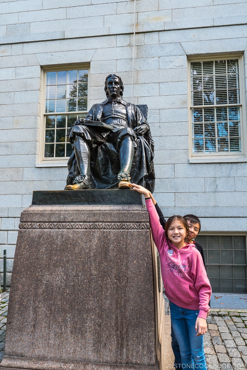 two children touching the toe of John Harvard statue