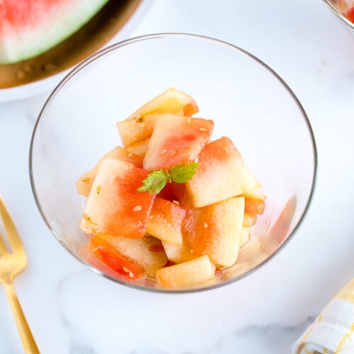 A round glass bowl containing Pickled Watermelon Rind.