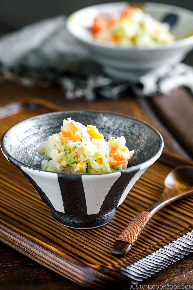 A black and white ceramic bowl containing Japanese potato salad.