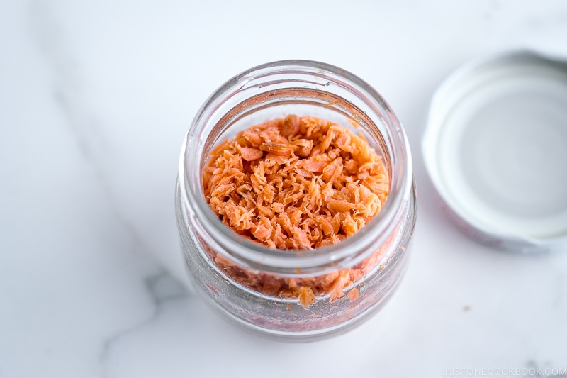 A glass jar containing salmon flakes.