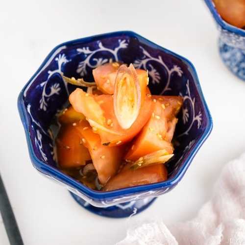 A blue and white bowl containing Tomato Myoga Salad.