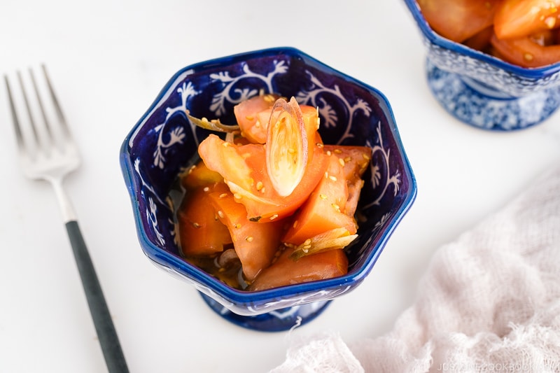 A blue and white bowl containing Tomato Myoga Salad.