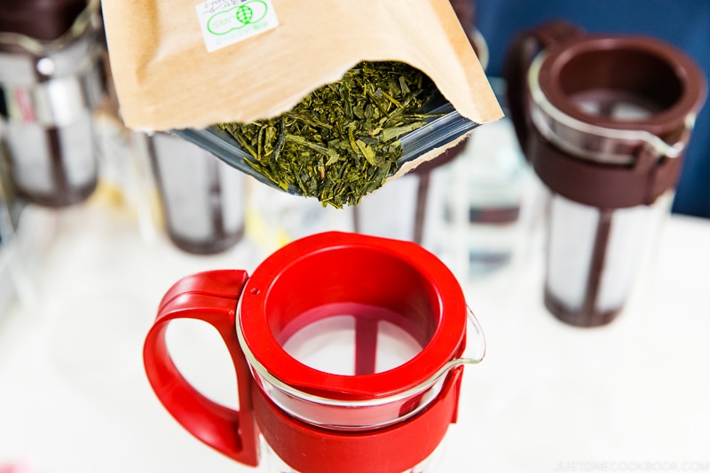 green tea leaves being pour into a cold brew pitcher