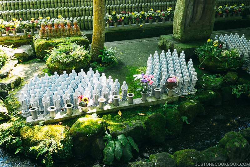 small jizo statues in a garden area