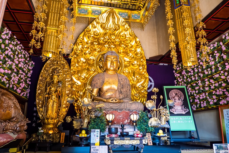 a large golden deity statue inside a temple