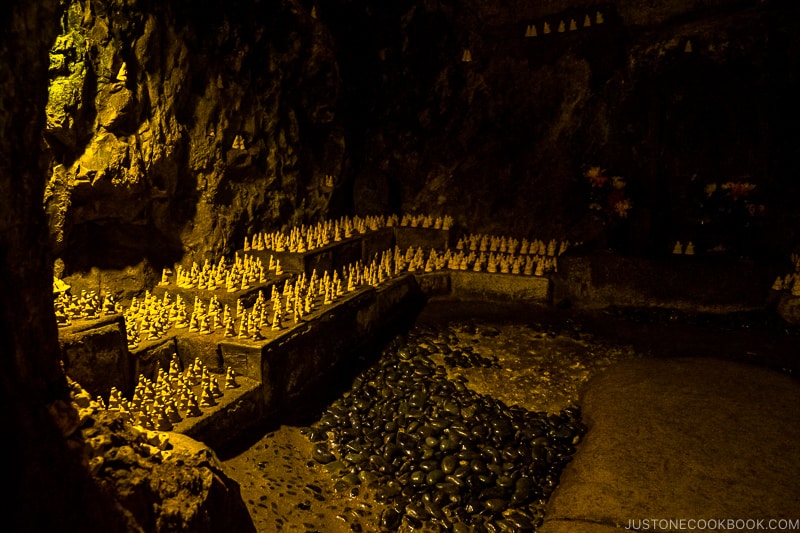 small jizo statues lined up inside a cave