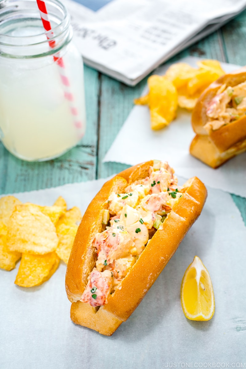 Lobster Roll served along with potato chips and lemon.