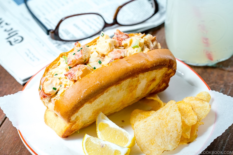 Lobster Roll served along with potato chips and lemon.