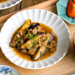 A white plate containing Mapo Eggplant (Mabo Nasu).