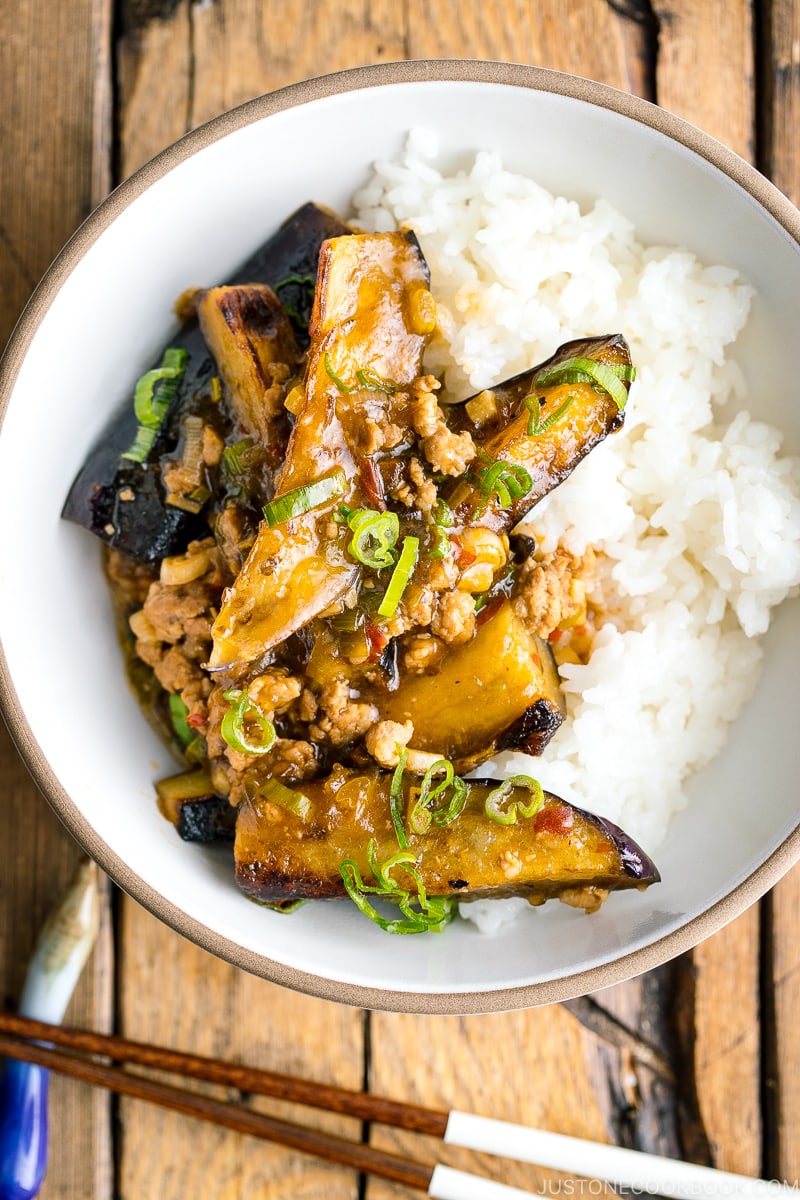 A white bowl containing Mapo Eggplant (Mabo Nasu) served over steamed rice.