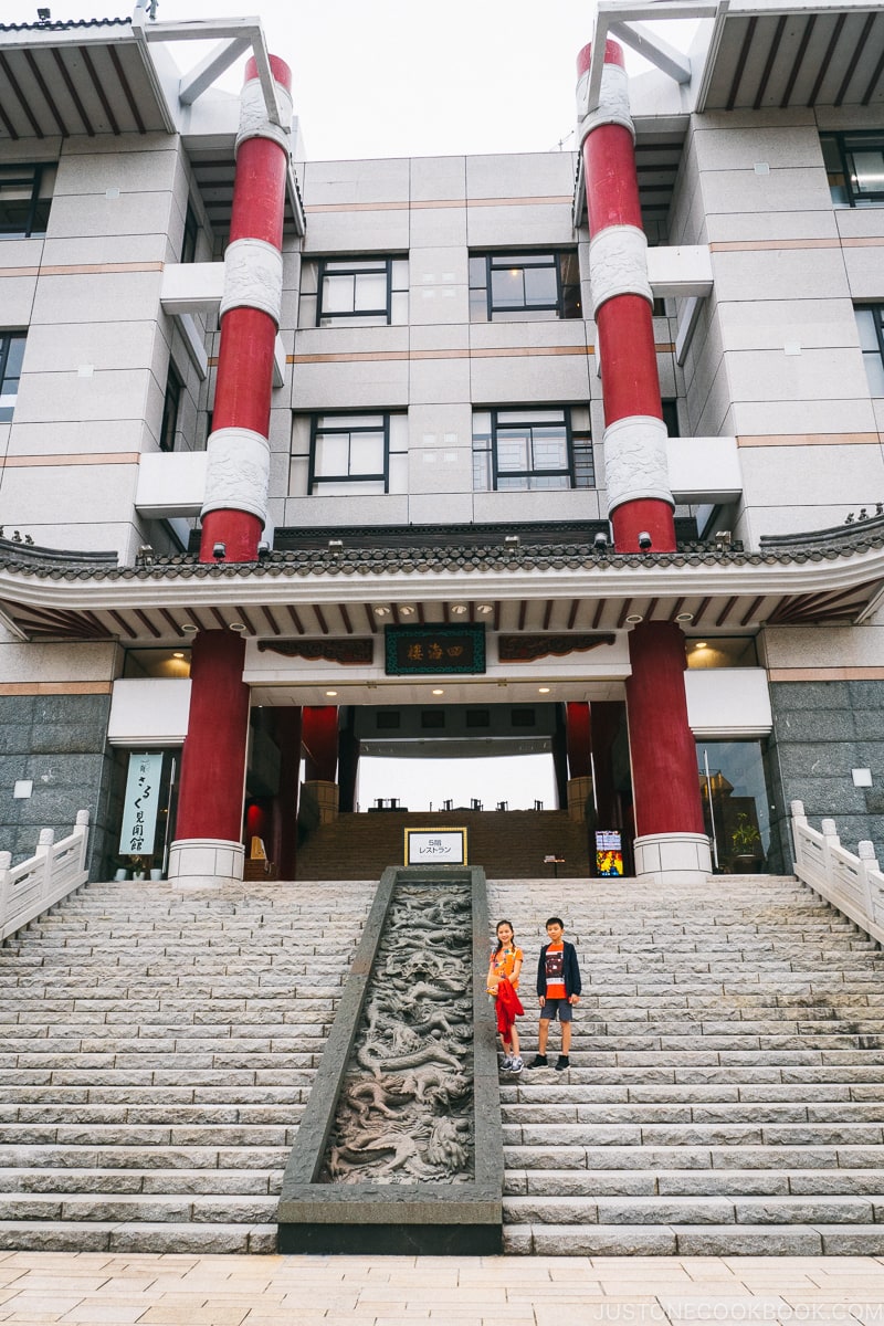 two children on stone steps in front of a building