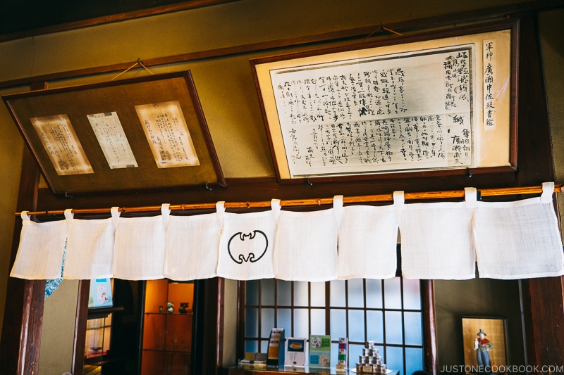 old framed prints hanging on a wall above a white banner with bat