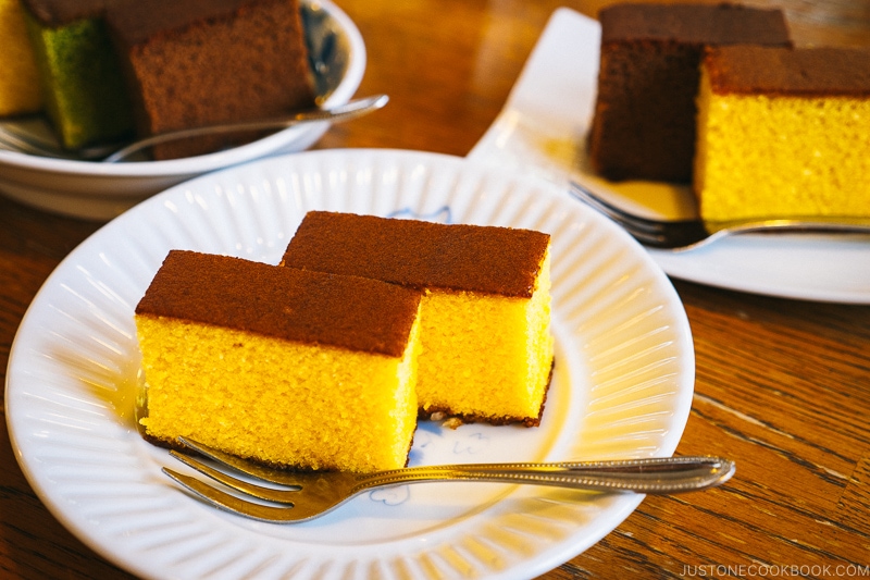 castella cake on a white plate with a fork